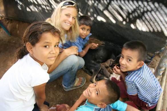 Holly with kids in Nicaragua checking out new puppies