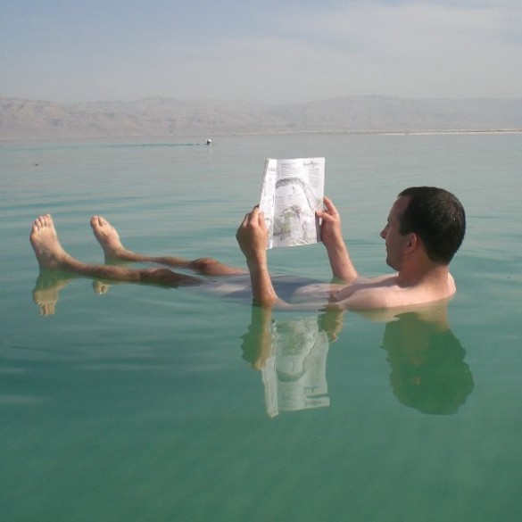A man reads while floating in the Dead Sea, Ein Gedi, Israel