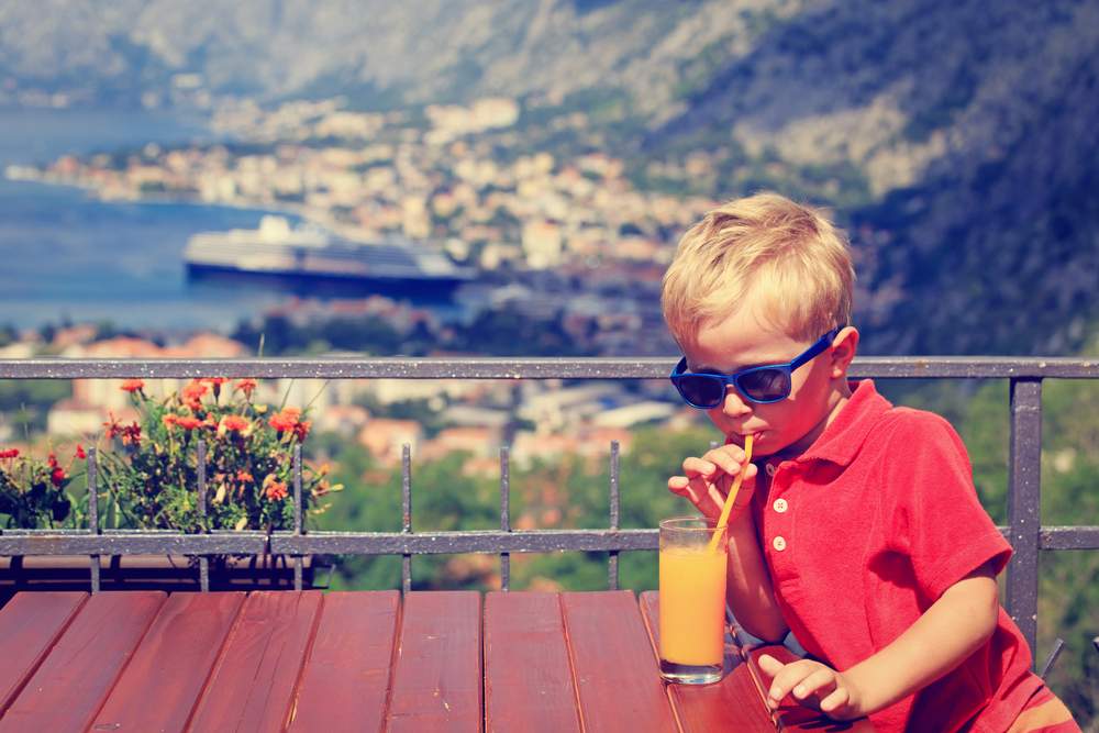 kid in Croatia, drinking juice with a view